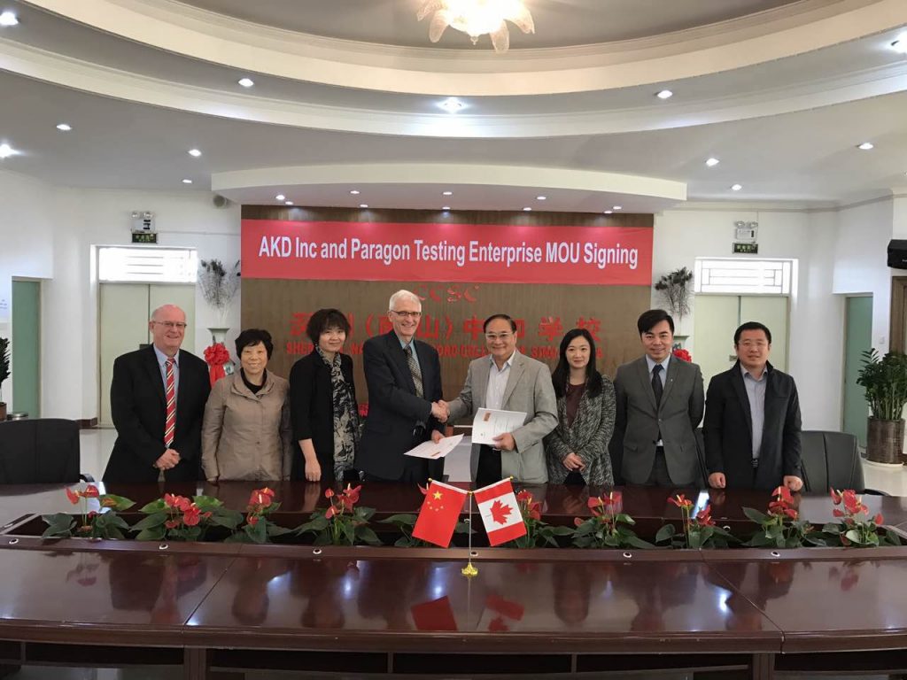Dr. Donald Wehrung, CEO of Paragon Testing Enterprises, and Dr. Francis Pang, chairman of AKD Inc., shaking hands at the signing ceremony in Shenzhen, China.